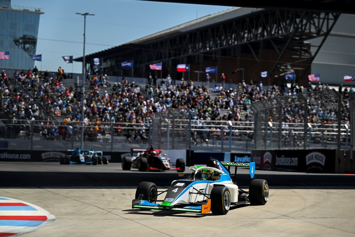 USF Pro 2000 cars racing wheel to wheel in front of a full grandstand