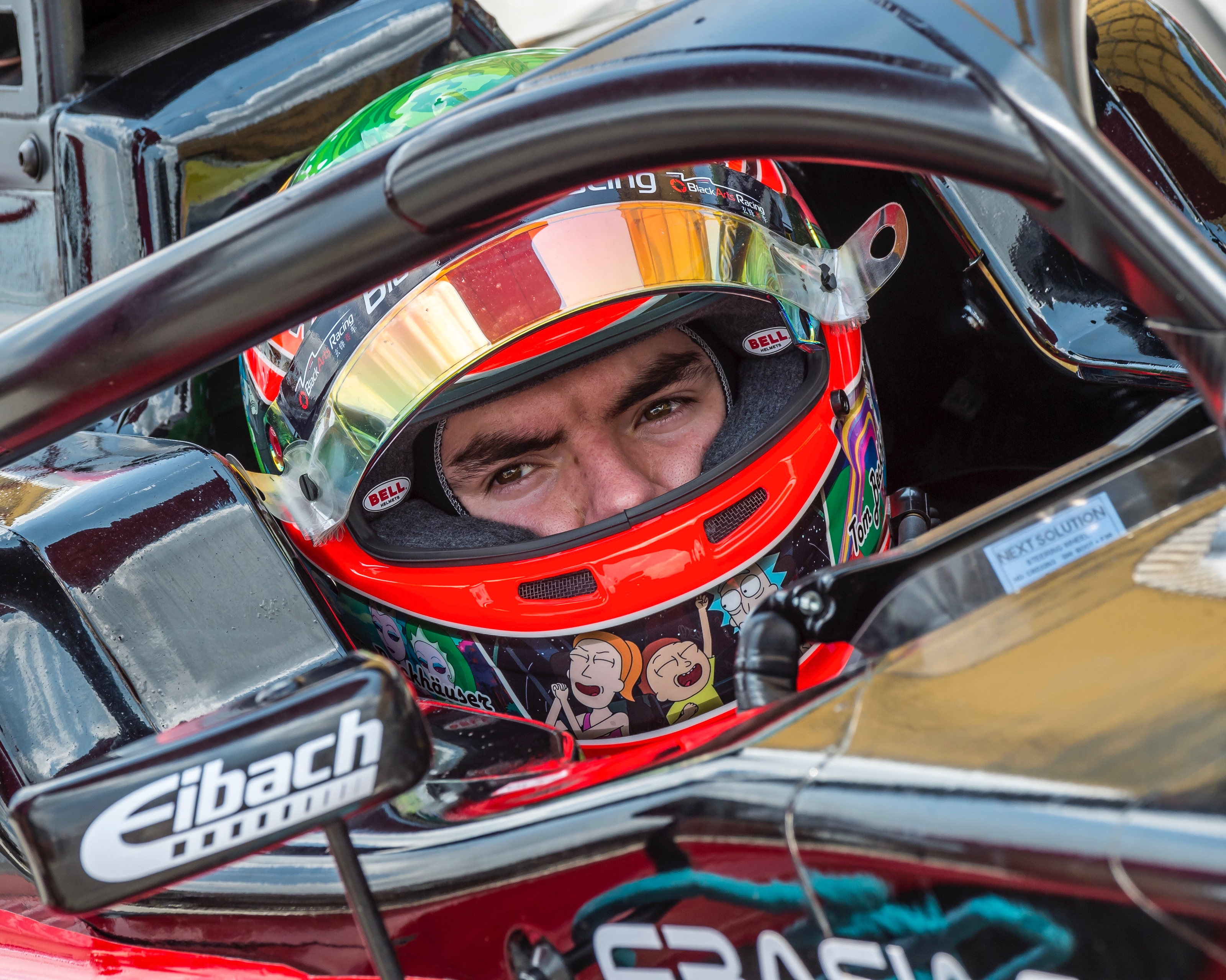 Tom Beckhäuser strapped into the cockpit, helmet on and focused before a session